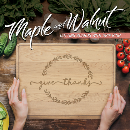 Wooden cutting board with 'give thanks' engraving on a wooden surface with vegetables.